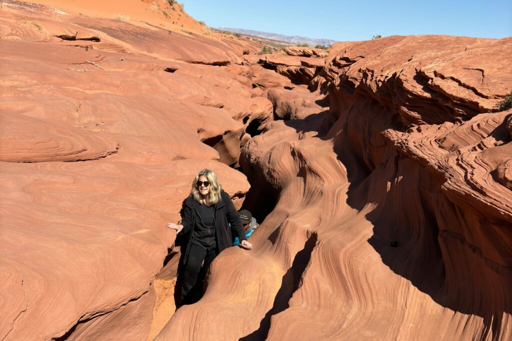 Diane Hatz climbing out of Antelope Canyon red rocks